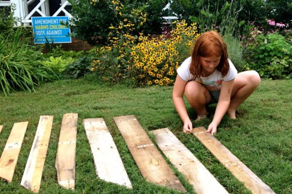 Original art created by Laurie Smithwick (and family) for Yard Art Day in Charlotte, NC. The piece is a riff on the picket fence that doesn't actually keep anyone out, called "What's (Y)Ours is..."