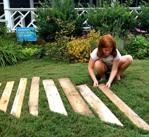 Original art created by Laurie Smithwick (and family) for Yard Art Day in Charlotte, NC. The piece is a riff on the picket fence that doesn't actually keep anyone out, called "What's (Y)Ours is..."