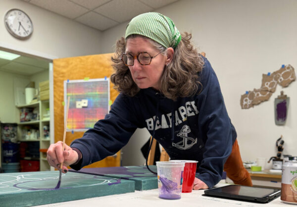 Laurie Smithwick in her studio, concentrating while working on a painting.