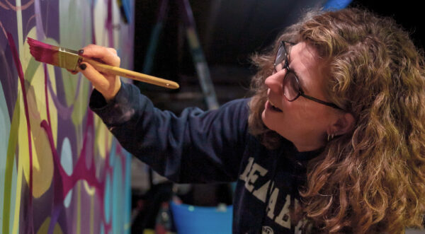 Laurie Smithwick painting a mural at Novant Health in Charlotte, NC